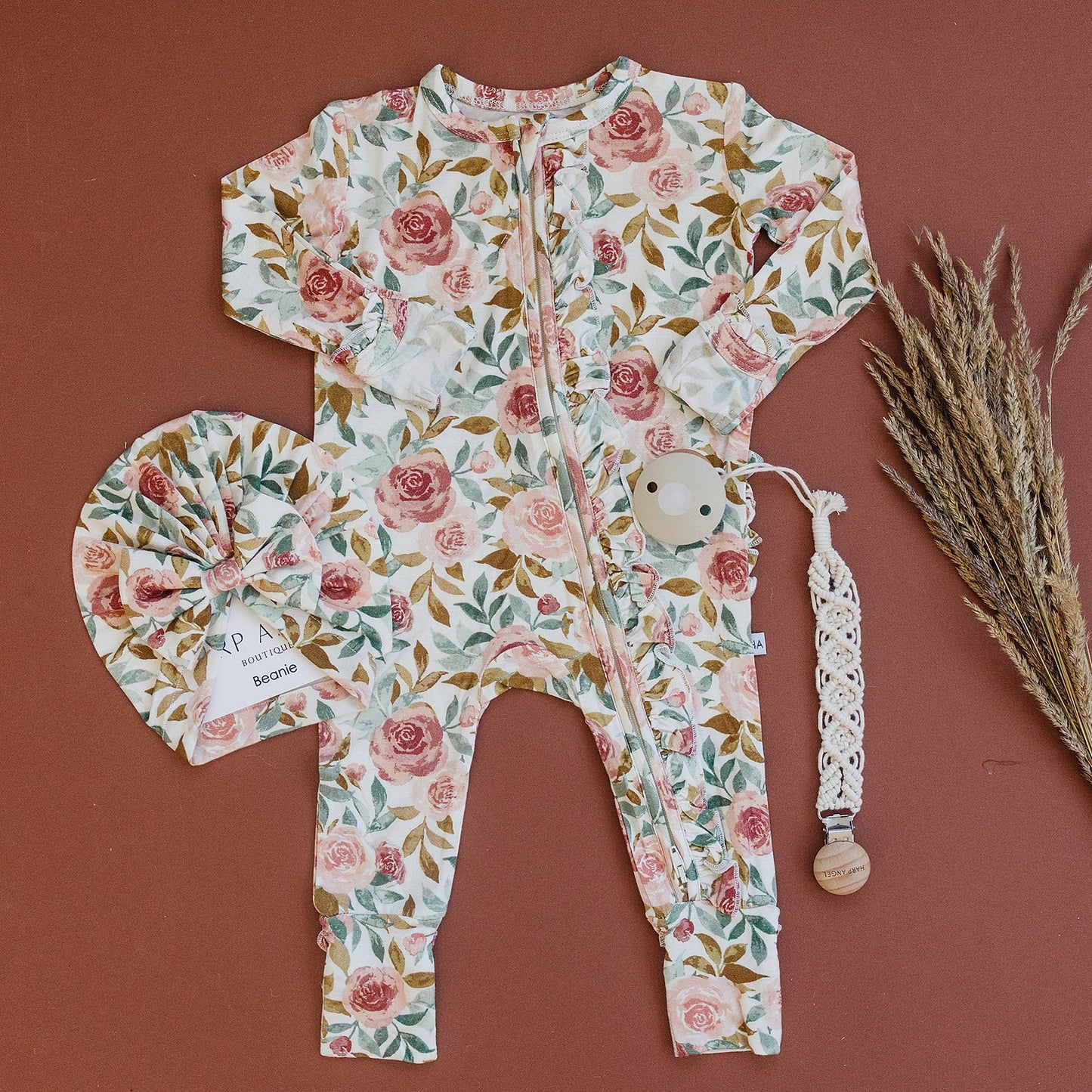 Dusty pink floral bamboo ruffle baby outfit with 2-way zipper, fold-over feet and hand cuffs for babies.