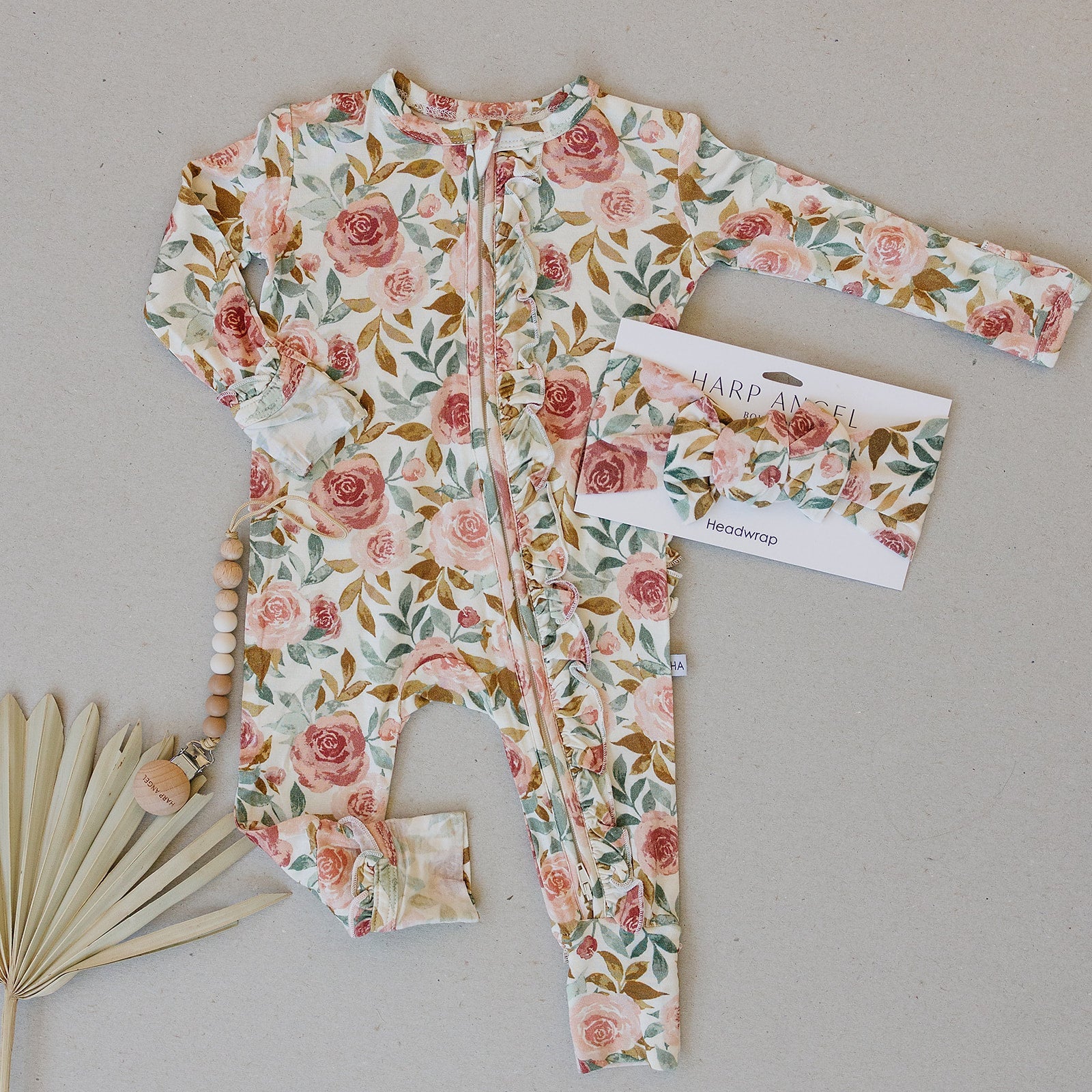 Dusty pink floral bamboo ruffle baby outfit with 2-way zipper, fold-over feet and hand cuffs for babies.