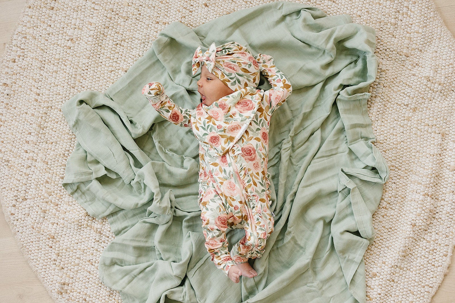 Dusty pink floral bamboo ruffle baby outfit with 2-way zipper, fold-over feet and hand cuffs for babies.